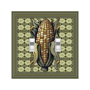 May include: A light switch cover with a green background and a detailed illustration of an ear of corn. The corn is surrounded by a decorative border of green leaves and gold accents.