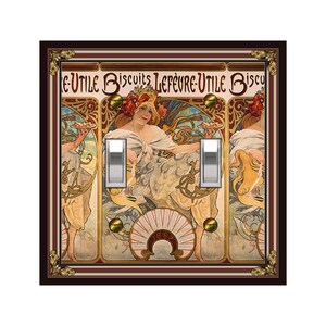 May include: A decorative light switch cover featuring an Art Nouveau design with a woman holding a plate of biscuits. The design includes the text "LEFEVRE-UTILE Biscuits" and is framed in a dark brown border with gold accents. The cover has two silver toggle switches.