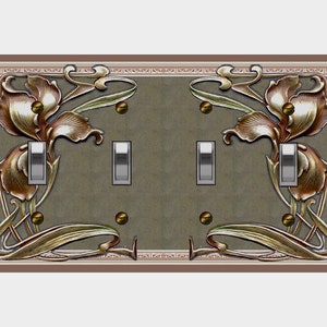 Puede incluir: Una placa de interruptor doble con un diseño decorativo de iris estilizados en oro y marrón sobre un fondo verde.
