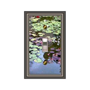 May include: A decorative light switch cover featuring a serene pond scene with lily pads and reflections. The image is framed with a dark gray border and includes a silver toggle switch.