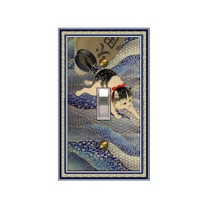 May include: A light switch cover featuring a Japanese-style illustration of a white and black cat playing with a ball. The cat is wearing a red bow and is surrounded by blue and gold patterned waves. The switch cover is framed in a gold and blue border.