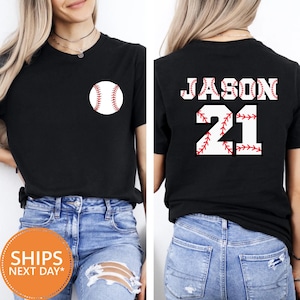 May include: Black t-shirt with a baseball graphic on the front and the name "JASON" and the number "21" on the back. The baseball graphic and text are in white with red stitching details.