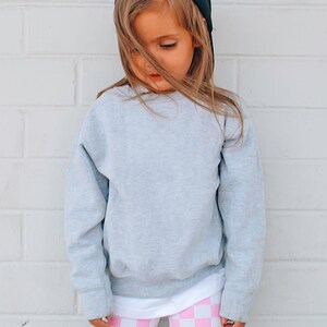 a little girl wearing pink and white checkered leggings