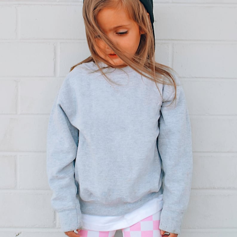 a little girl wearing pink and white checkered leggings