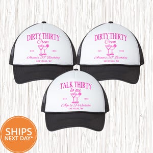 May include: Three black and white trucker hats with pink text. Two hats read "DIRTY THIRTY Crew" with "Ariane's 30th Birthday" and "Las Vegas, NV." The third hat says "TALK THIRTY to me" with "Age to Perfection" and "Las Vegas, NV."