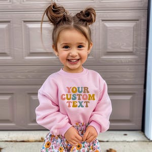 a little girl standing in front of a garage door