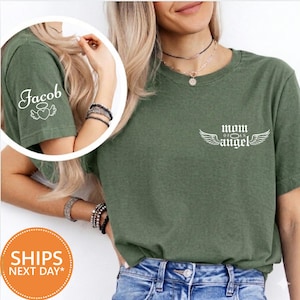 A woman wearing a green t-shirt with the text "Mom of an Angel" printed on it, along with a necklace and bracelets.
