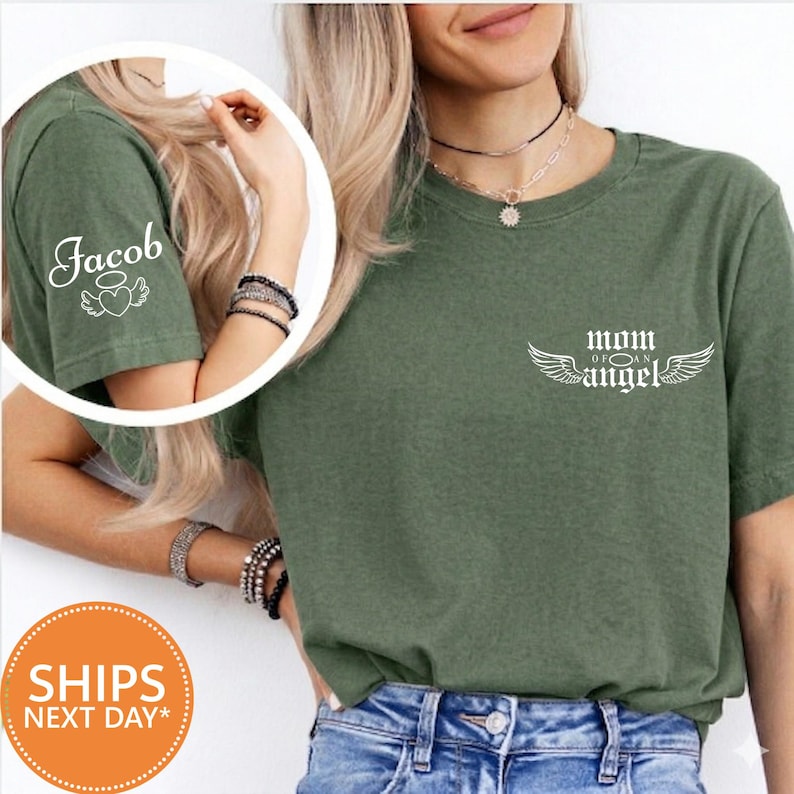 A woman wearing a green t-shirt with the text "Mom of an Angel" printed on it, along with a necklace and bracelets.