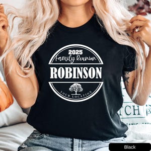 a woman with long blonde hair wearing a black robinson t - shirt