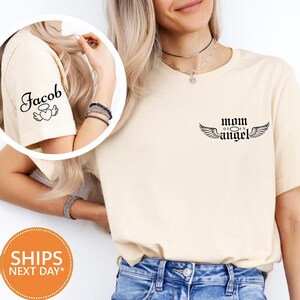 A woman wearing a white t-shirt with a graphic design and text, posing against a white background.