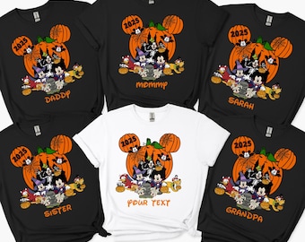 May include: Black and white t-shirts with a Halloween-themed graphic featuring Mickey Mouse and friends in front of a pumpkin. The shirts have the year 2025 and various names like "Daddy", "Mommy", "Sister", "Sarah", "Grandpa", and "Your Text".