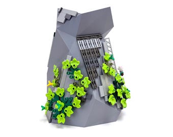 Peut inclure: Un modèle de falaise rocheuse en Lego gris avec des vignes vertes qui poussent sur le côté. La falaise est faite de briques Lego et a une surface texturée. Les vignes sont faites de feuilles Lego et sont disposées en cascade.