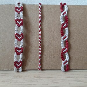 Könnte beinhalten: Drei Freundschaftsarmbänder aus rotem und weißem Garn. Die Armbänder haben verschiedene Muster, darunter Herzen und ein geflochtenes Design.