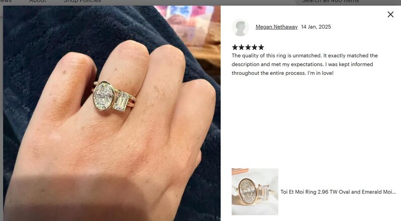 May include: A gold ring with an oval-cut diamond and an emerald-cut diamond. The ring is on a person's finger. The ring is a Toi Et Moi style. The ring is set with diamonds. The ring is a piece of jewelry.