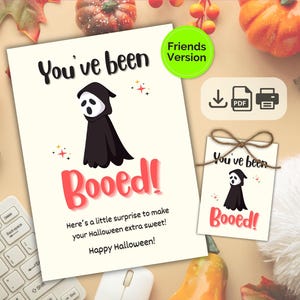 May include: A Halloween card and tag set featuring a cartoon ghost in a black cloak. The card says "You've been Booed!" in black and red, with "Friends Version" in a green circle. Includes a PDF download icon.