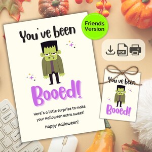 May include: A Halloween card and tag set with a cartoon Frankenstein's monster. The card reads "You've been Booed!" in black and purple. The tag has the same design. Includes a "Friends Version" badge. The image also shows pumpkins and autumn leaves.