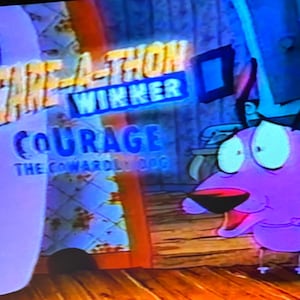 Puede incluir: Una imagen fija de la serie de televisión animada, Courage the Cowardly Dog. La imagen presenta el título del programa y las palabras "Scare-A-Thon Winner". Courage, un perro rosa con ojos grandes, está en primer plano.