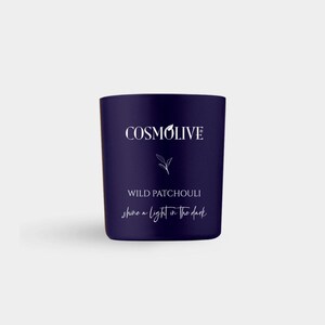 May include: A dark blue candle with the text "COSMOLIVE" in white. Below, it reads "WILD PATCHOULI" and "shine a light in the dark". The candle is a cylindrical shape and sits on a white surface.