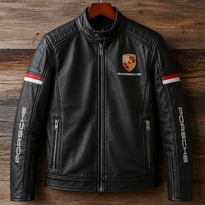Puede incluir: Chaqueta de cuero negra con cuello alzado, logotipo de Porsche en el pecho y la palabra "PORSCHE" en blanco en las mangas. Rayas rojas y blancas en la parte superior del brazo. Diseño clásico.