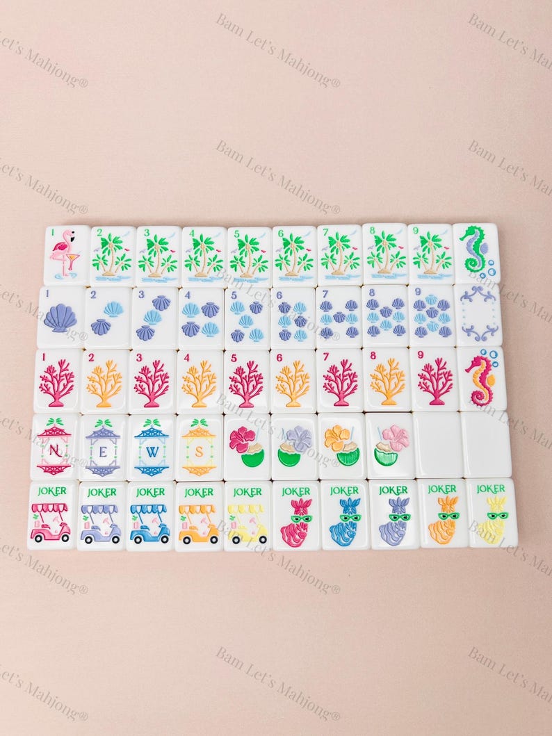 May include: A set of white Mahjong tiles with colorful illustrations. The tiles feature images of palm trees, seashells, coral, and seahorses. Some tiles have the word "JOKER" and images of golf carts and llamas.