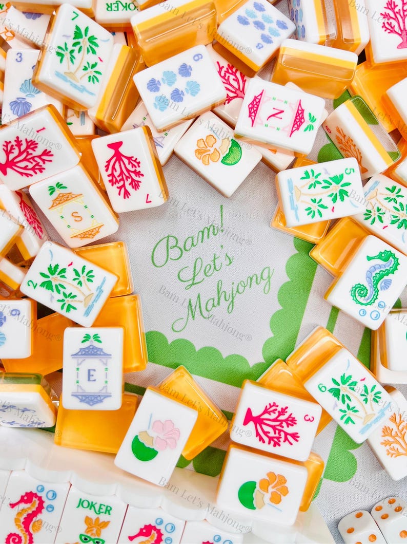 May include: A collection of white and orange Mahjong tiles with various colorful illustrations, including palm trees, coral, and seahorses. The text "Bam! Let's Mahjong" is visible on a green and white background.