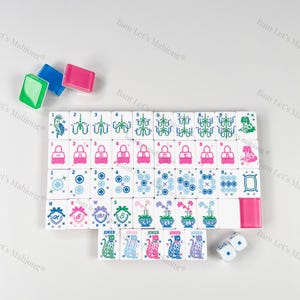 Peut inclure: Un jeu de Mahjong complet avec des tuiles blanches orn&eacute;es de motifs roses, bleus et verts. Comprend des d&eacute;s et des supports de tuiles color&eacute;s. Les tuiles affichent divers symboles et chiffres.