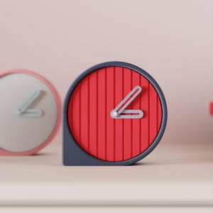 Puede incluir: Un reloj moderno y minimalista con esfera roja y manecillas grises. El reloj tiene un marco y una base grises, y la esfera presenta líneas verticales. En el fondo se ve otro reloj con marco rosa y esfera blanca.