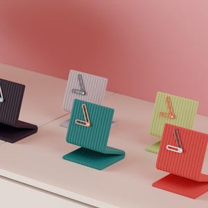 Può includere: Una collezione di orologi da scrivania moderni e colorati in varie tonalità, tra cui nero, verde acqua, grigio, verde e rosso. Ogni orologio presenta un design unico con un'estetica minimalista, perfetto per l'arredamento della casa o dell'ufficio.