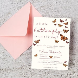 May include: A white baby shower invitation with a pink envelope. The invitation features a pink and brown butterfly design with the text "a little butterfly is on the way!" and the name "Ava Roberts". The invitation also includes the date, time, and location of the shower.