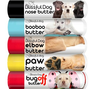 May include: Five tubes of dog balm with different scents and purposes. The tubes are labeled "nose butter", "booboo butter", "elbow butter", "paw butter", and "bugoff butter". Each tube features a different image of a dog.