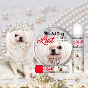 May include: Three different sizes of a product called "The Blissful Dog Lust Buster Butter" featuring a white chihuahua wearing a crown and a pearl necklace. The product is in a white jar, a red tube, and a clear tube.