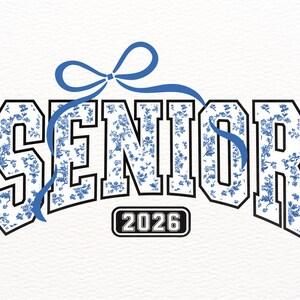 May include: A white graphic tee with a blue floral pattern spelling "SENIOR" with a blue ribbon bow above the text and "2026" below the text.