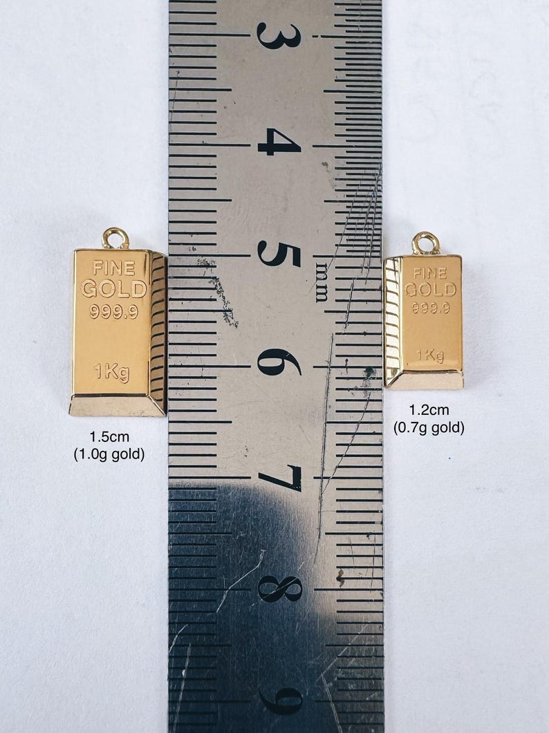 May include: Two gold bars, one measuring 1.5 inches and weighing 1.0 grams, and the other measuring 1.2 inches and weighing 0.7 grams. Both bars are labeled "FINE GOLD 999.9 1Kg".