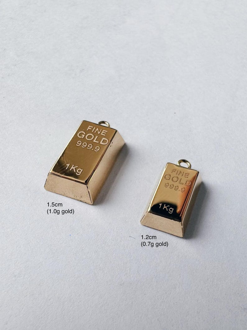May include: Two gold-colored bars with "FINE GOLD 999.9" and "1Kg" printed on them. The larger bar is 1.5 inches (1.0g gold) and the smaller bar is 1.2 inches (0.7g gold).