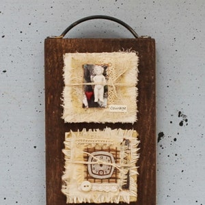 May include: A wooden plaque with four fabric squares attached. Each square has a different design and includes a button, lace, and twine. The squares are labeled "Courage", "Wonder", and "3".
