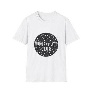 May include: White t-shirt with a black circle graphic that says "Vulnerability Club" in white text.
