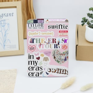 May include: Pink background with various stickers featuring Taylor Swift's "The Eras Tour" theme. Stickers include the tour title, "Taylor's Version", "Swiftie", and a heart with the words "Taylor Swift".