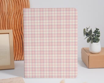 Può includere: Un raccoglitore rettangolare caratterizzato da un motivo a quadri rosa chiaro e bianco. Il raccoglitore presenta un design pulito e strutturato con una griglia coerente di linee orizzontali e verticali che si incrociano in tenui toni pastello.