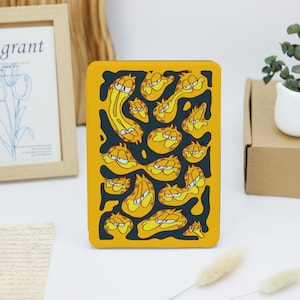 May include: A yellow and black phone case with a repeating pattern of Garfield's face in different expressions.