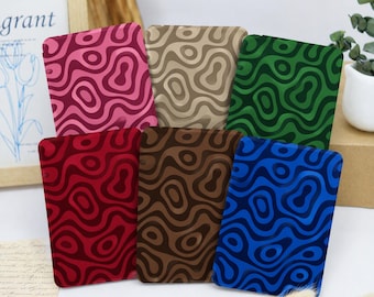 May include: A collection of six rectangular covers featuring a wavy, topographic-style pattern in various colors including pink, beige, green, red, brown, and blue. Each cover displays a consistent, repeating abstract design of fluid lines.