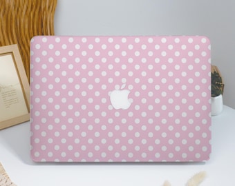 May include: A pink laptop case with a white polka dot pattern. The case features a white Apple logo in the center. The case is on a white surface.