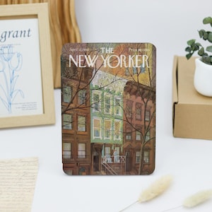 May include: A vintage New Yorker magazine cover featuring an illustration of a city street scene with brownstone buildings and trees. The cover is dated April 12, 1980, and the magazine's title is printed in white letters on a red background.