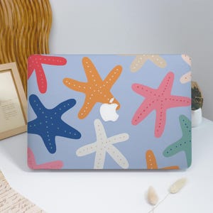 Könnte beinhalten: Eine hellblaue Laptop-Hülle mit einem Muster aus bunten Seesternen. Die Seesterne sind in den Farbtönen Rot, Orange, Rosa, Blau und Grün gehalten, jeweils mit gepunkteten Details. Das Apple-Logo ist in der Mitte sichtbar.