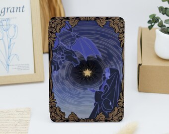 Könnte beinhalten: Eine dekorative Karte mit goldenem Rahmen und einer blauen und violetten Illustration eines Drachen und einer Person, die nach einem Stern greift.