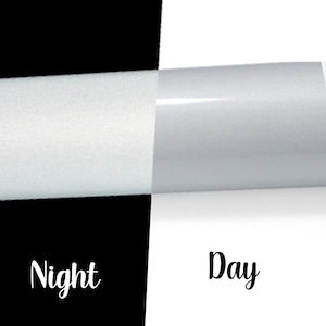May include: A split image with a black and white background. The left side is black with the word "Night" in white script. The right side is white with the word "Day" in black script. The image shows a roll of white material.