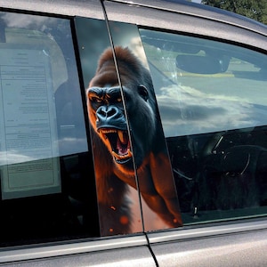 May include: A close-up of a car window with a gorilla graphic decal. The gorilla is depicted with a fierce expression, its mouth open in a roar. The decal is printed in vibrant colors and appears to be high-quality.