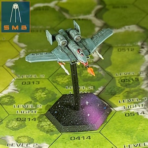 May include: A gray and white miniature spaceship with red accents, mounted on a black base with a galaxy design. The spaceship has two engines and a pointed nose.