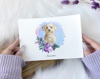 May include: Watercolor painting of a small, light brown dog with a white chest and a fluffy tail. The dog is surrounded by purple flowers and green leaves. The painting has a light blue background and the name "Snower" is written below the dog.