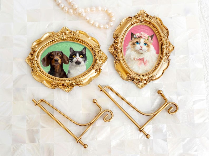 Two vintage-style acrylic pet portraits in ornate gold frames, featuring a Dachshund and a tuxedo cat in one, and a Ragdoll cat with a pink background in the