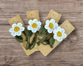 May include: Four crocheted white daisy flowers with yellow centers and green leaves attached to brown card stock with the text "Handmade with Love" in a circle.